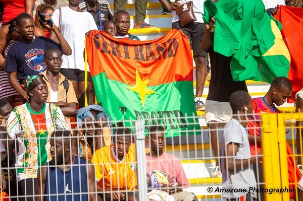Des supporters tenant un drapeau à l'effigie de Bertrand Traoré, Capitaine de l'équipe des Étalons