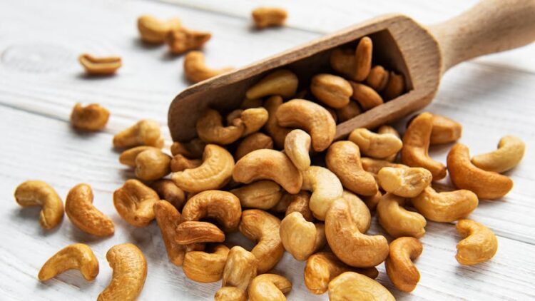 Tasty cashew nuts in scoop on a old wooden table